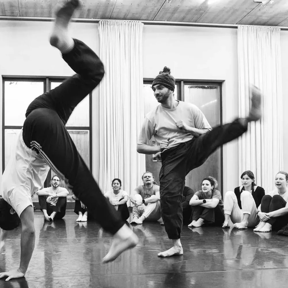 Ein Kick im Capoeira-Spiel, umringt von der Roda